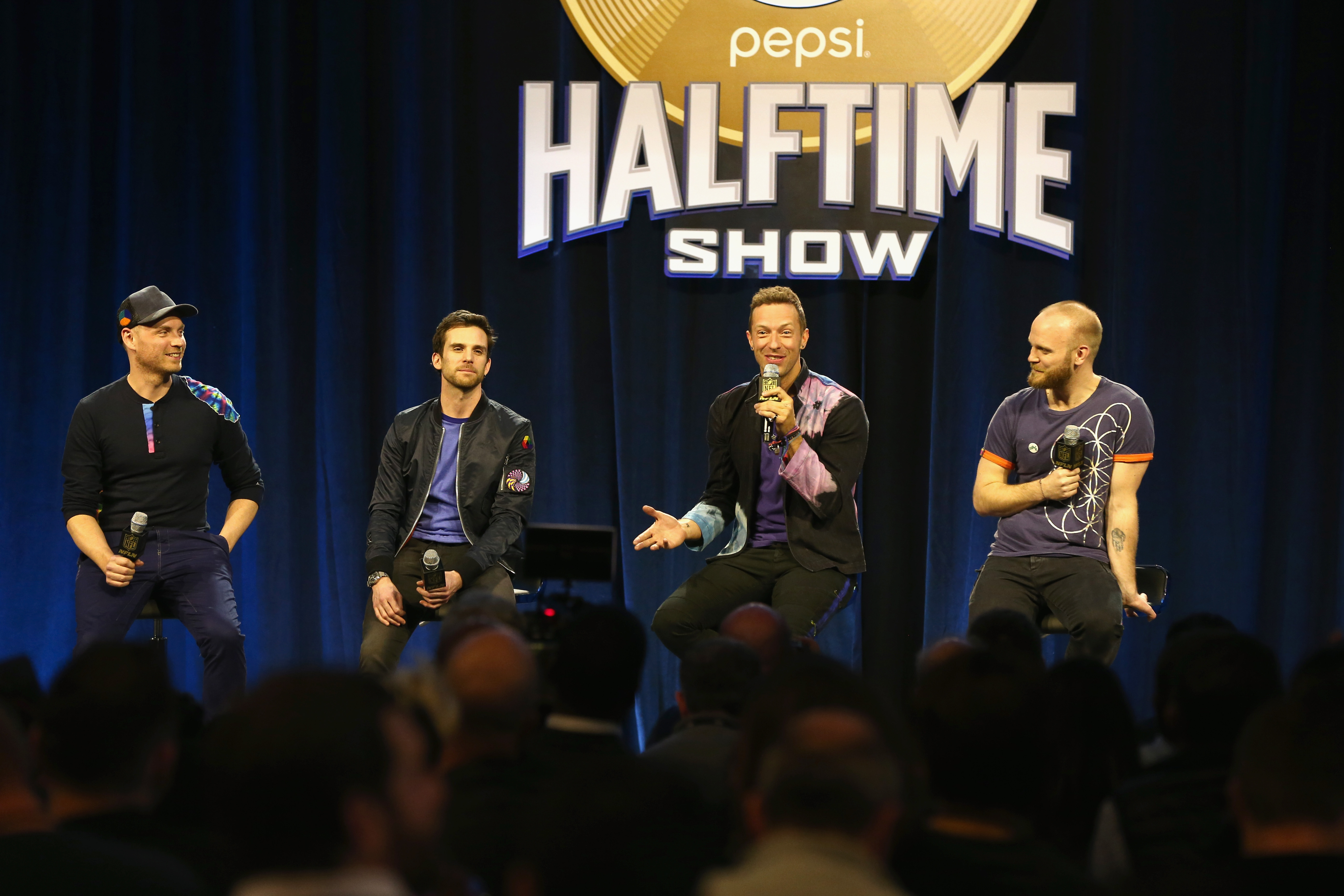 Jonny Buckland, Guy Berryman, Chris Martin y Will Champion de Coldplay en el escenario en la conferencia de prensa de Super Bowl medio tiempo de Super Pepsi. (Getty)
