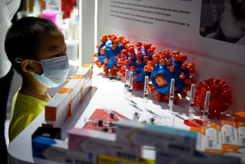 China: Niño mirando una simulación de la vacuna para el COVID-19.