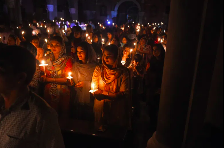 Devotos cristianos paquistaníes sosteniendo velas mientras asisten a una misa de vigilia de Pascua en la Iglesia del Sagrado Corazón en Lahore el 31 de marzo de 2018.
