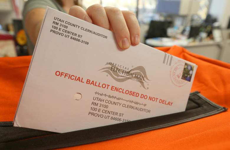 6 de noviembre: un empleado de la oficina de elecciones del condado de Utah coloca las papeletas en un contenedor para registrar el voto en las elecciones de mitad de período del 6 de noviembre de 2018 en Provo, Utah.