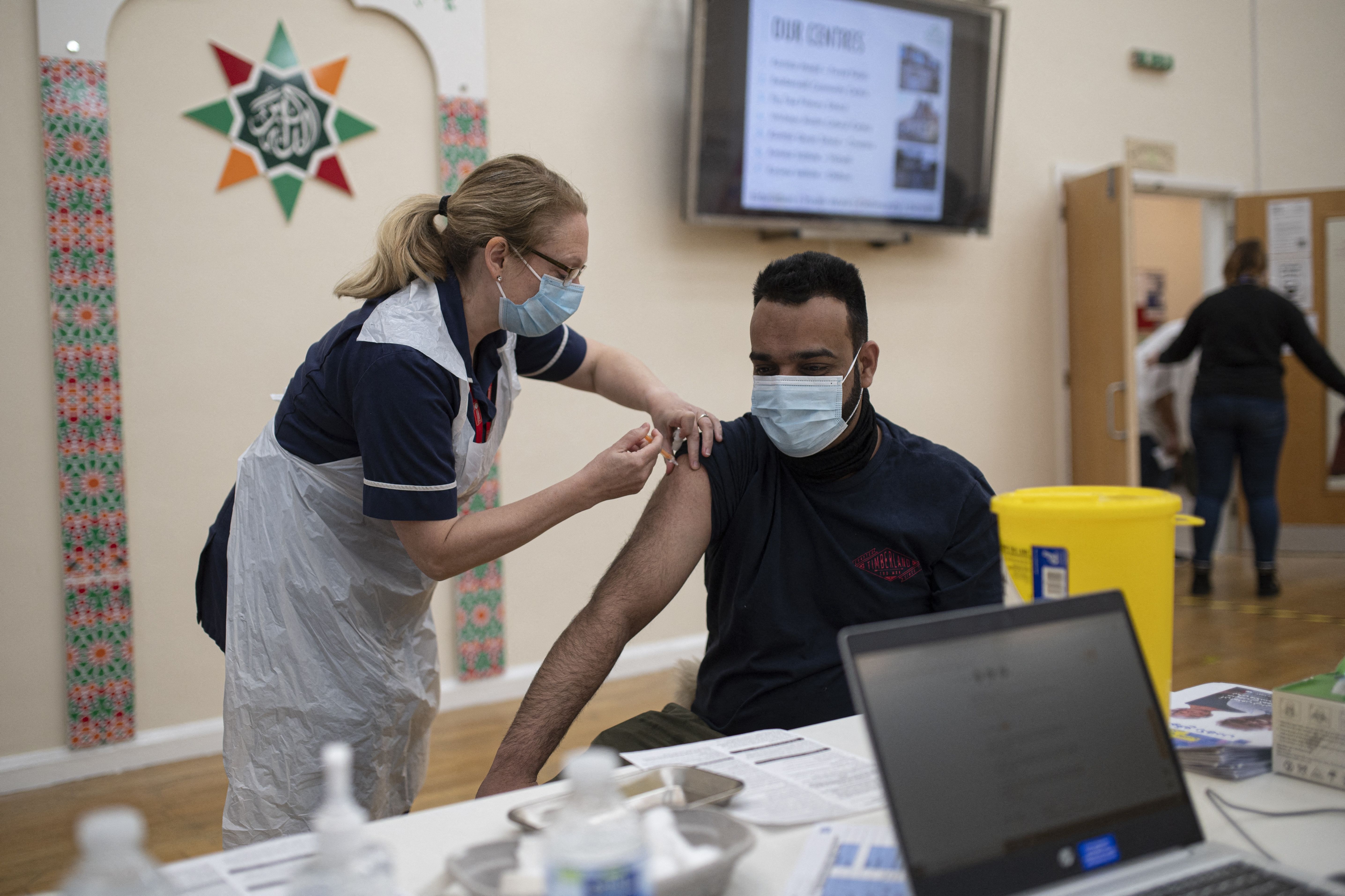 Un trabajador de la salud administra una dosis de la vacuna AstraZeneca / Oxford Covid-19 a un paciente en un centro de vacunación establecido en el centro islámico y mezquita del Instituto Karimia en Nottingham, en el centro de Inglaterra, el 6 de abril de 2021