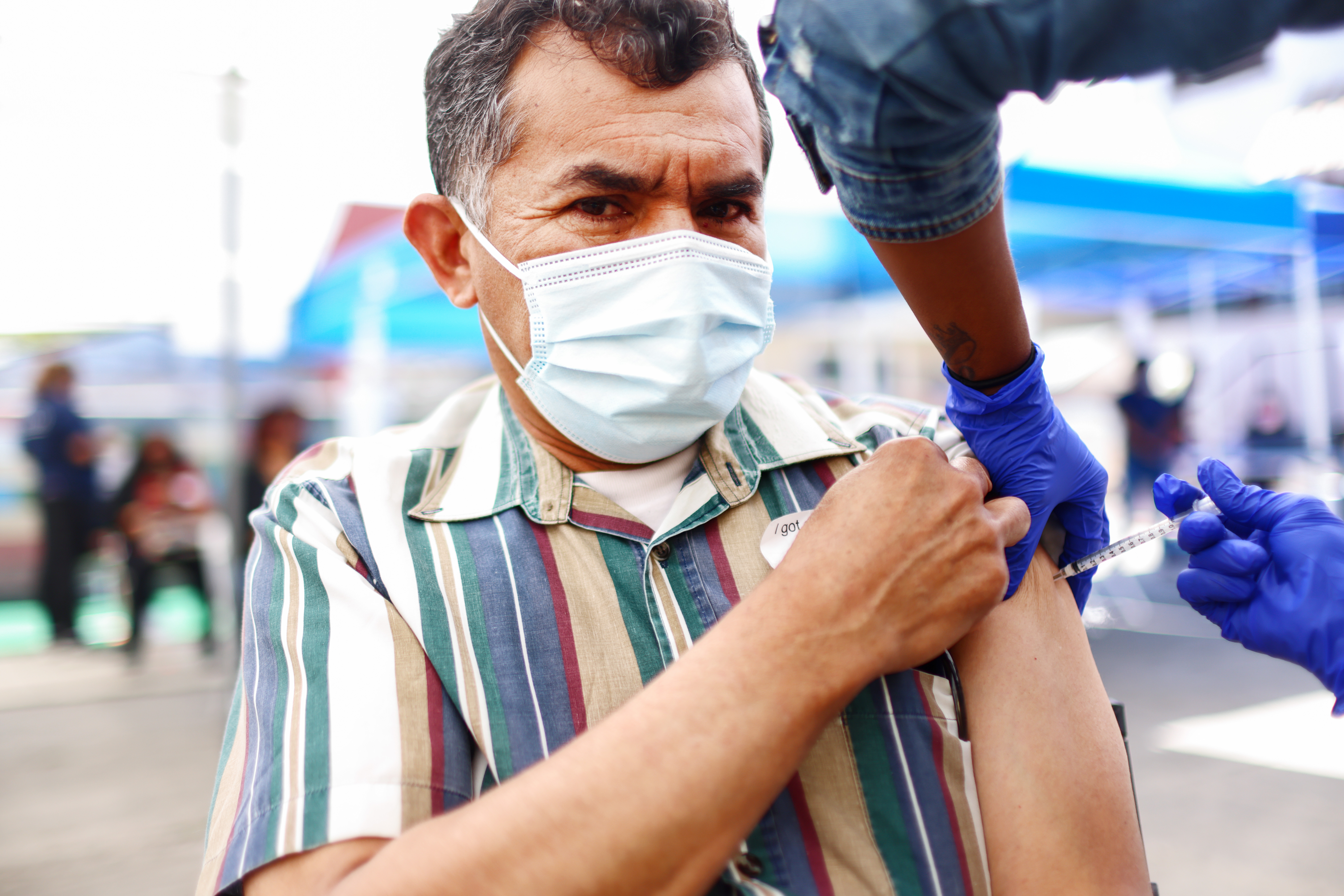 Carlos Anaya recibe su primera dosis de la vacuna Pfizer COVID-19 de un trabajador de la salud en una clínica dirigida a residentes indígenas centroamericanos en CIELO, una organización de derechos indígenas, el 10 de abril de 2021 en Los Ángeles , California.