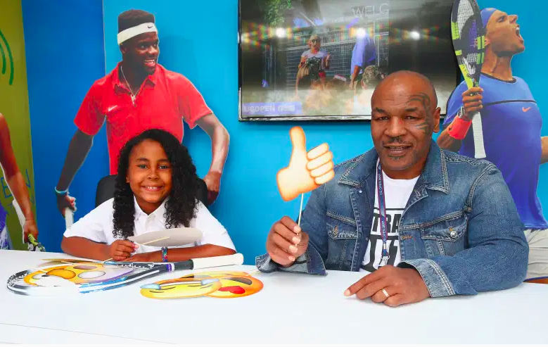 Mike Tyson (R) y su hija Milan (L) son vistos en el stand de Kidcaster para Net Generation el primer día durante el US Open 2017 en el USTA Billie Jean King National Tennis Center el 28 de agosto de 2017 en el distrito de Queens de la ciudad de Nueva York .