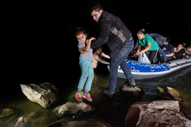 Un inmigrante levanta a un niño de un bote a la orilla del Río Grande después de haber sido contrabandeado a través de la frontera entre Estados Unidos y México el 14 de abril de 2021 en Roma, Texas.