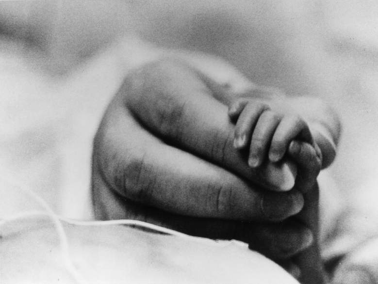 Primer plano de la bebé prematura Linda Lawrence de la mano de su madre Maureen.