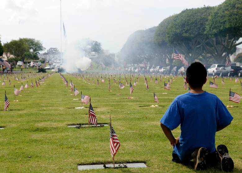 30 de mayo: Ryan Cabradilla de diez años de Kapolei, HI, observa el saludo de 21 cañones en la ceremonia del Día de los Caídos en el Cementerio Nacional Conmemorativo del Pacífico el 30 de mayo de 2005 en Honolulu, Hawaii.