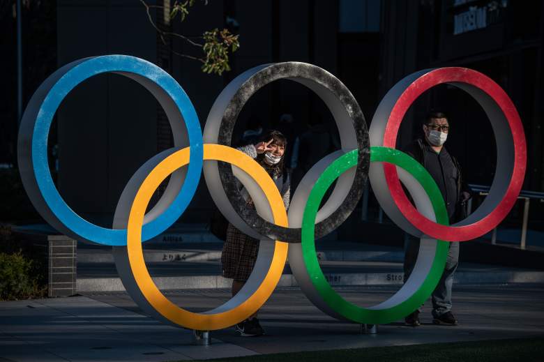 Personas con máscaras posan para fotografías junto a los Anillos Olímpicos el 24 de marzo de 2020 en Tokio, Japón.