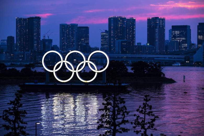 Una vista general muestra los anillos olímpicos iluminados al anochecer en el paseo marítimo de Odaiba en Tokio el 12 de Juky de 2021.