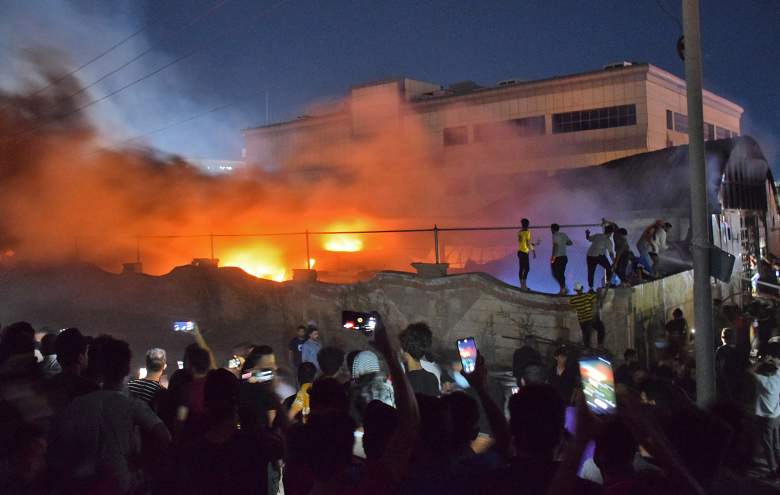 La gente se reúne cuando un incendio masivo envuelve la sala de aislamiento del coronavirus del hospital Al-Hussein en la ciudad de Nasiriyah, en el sur de Irak, a última hora del 12 de julio de 2021.