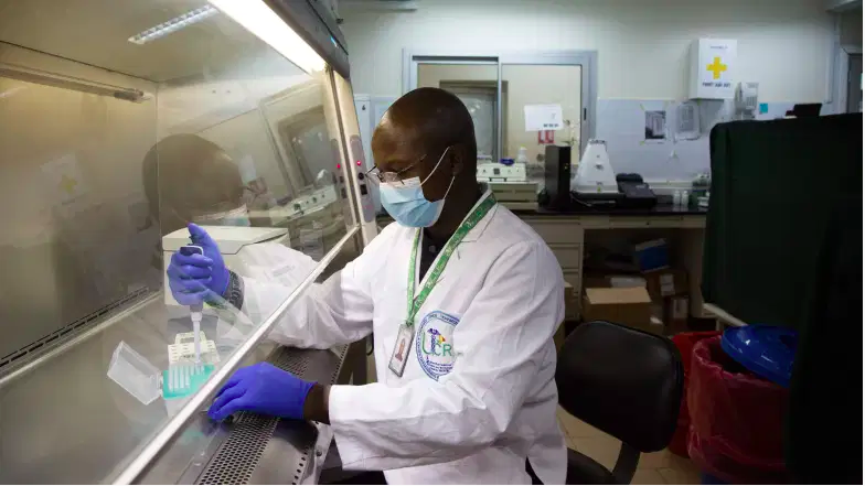 Se ve a Amadou Kone, profesor de biología molecular en el Centro de Investigación Clínica de la Universidad, trabajando en un laboratorio de pruebas Covid-19 en Bamako el 9 de enero de 2021.