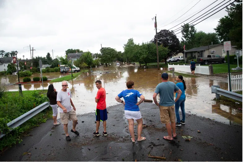 Los residentes examinan los daños por inundaciones a lo largo de John Street después de las inundaciones repentinas en el área, cuando la tormenta tropical Henri toca tierra, en Helmetta, Nueva Jersey, el 22 de agosto de 2021.