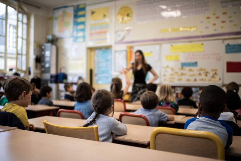 Los niños escuchan a su maestro mientras se sientan en un aula el primer día del inicio del año escolar, en la escuela primaria Chaptal en París, el 2 de septiembre de 2019