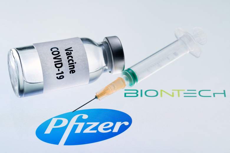 This illustration picture taken on November 23, 2020 shows a bottle reading "Vaccine Covid-19" and a syringe next to the Pfizer and Biontech logo.