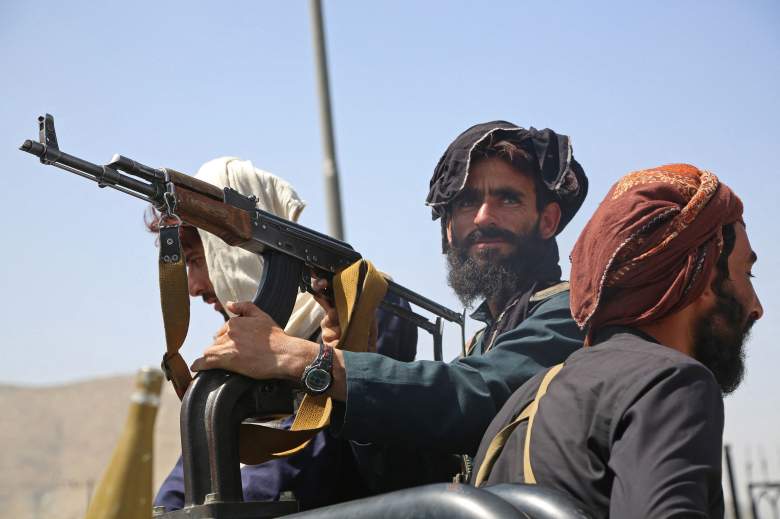 Los combatientes talibanes montan guardia en un vehículo a lo largo de la carretera en Kabul el 16 de agosto de 2021, después de un final asombrosamente rápido de la guerra de 20 años de Afganistán, mientras miles de personas asaltaban el aeropuerto de la ciudad tratando de huir de la temida línea dura de islamistas del grupo.
