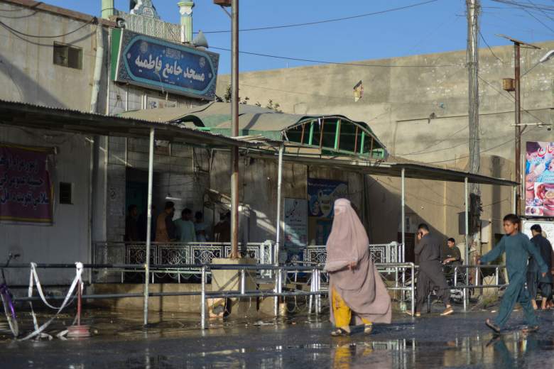 Una mujer vestida con burka pasa frente a la entrada de una mezquita chií en Kandahar el 15 de octubre de 2021, después de un ataque suicida con bomba durante las oraciones del viernes que mató al menos a 33 personas e hirió a otras 74, dijeron funcionarios talibanes.