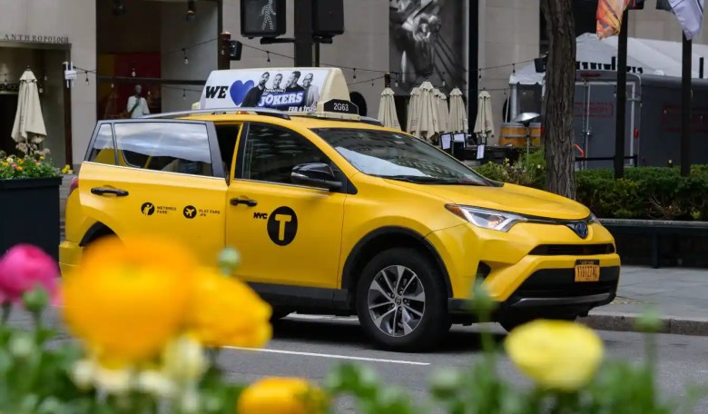 Una mujer y un taxi amarillo paran cerca del Rockefeller Center el 2 de abril de 2021.