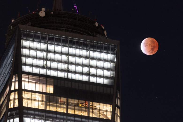 La luna se ve durante un eclipse lunar junto al One World Trade Center en Nueva York a principios del 19 de noviembre de 2021.