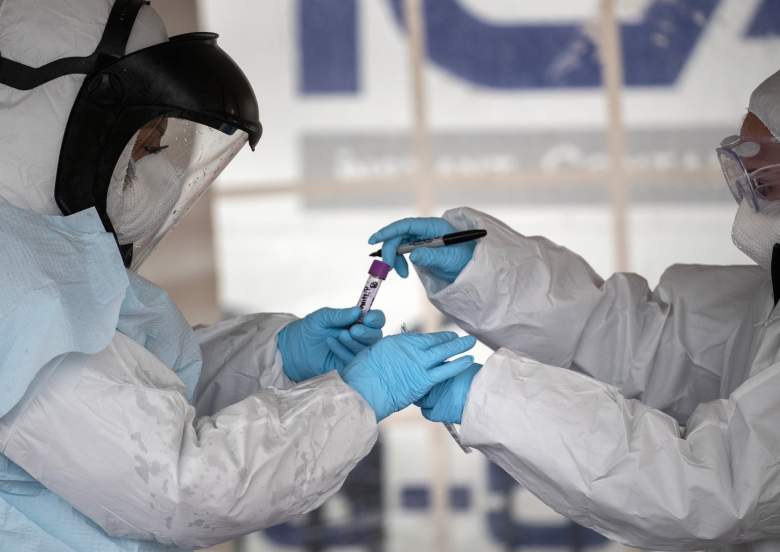 Los trabajadores de la salud vestidos con equipo de protección personal (PPE) manejan una prueba de coronavirus en una estación de prueba en Cummings Park el 23 de marzo de 2020 en Stamford, Connecticut.