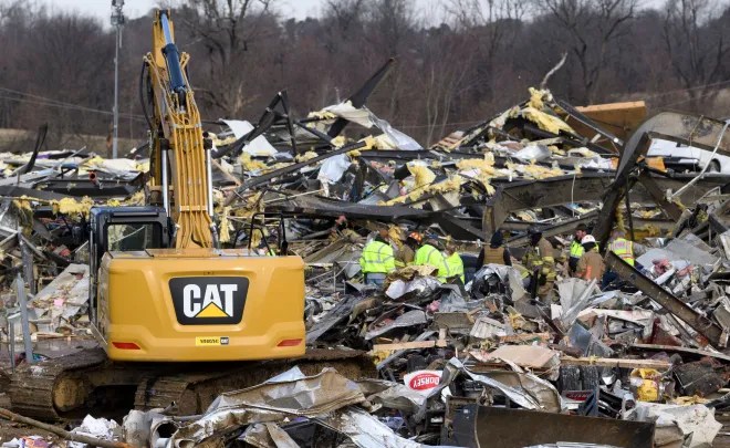Los trabajadores de emergencia registran lo que queda de Mayfield Consumer Products Candle Factory después de que fuera destruida por un tornado en Mayfield, Kentucky, el 11 de diciembre de 2021.