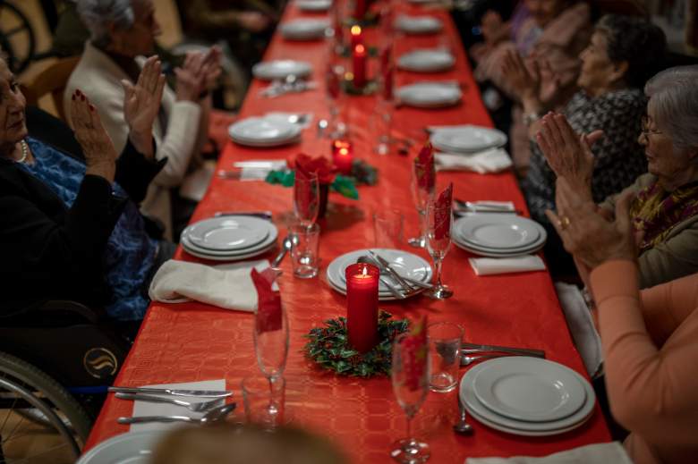 Los residentes mayores se sientan en una mesa con decoración navideña durante la cena de Nochebuena
