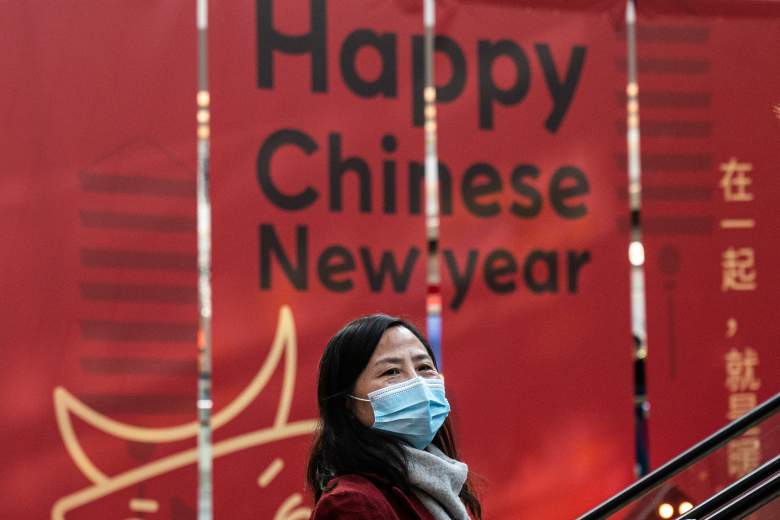 Una mujer usa una máscara mientras toma la escalera mecánica y pasa los lemas de la celebración del Año Nuevo Chino en el centro comercial durante el quinto día del Festival de Primavera el 16 de febrero de 2021 en Wuhan, provincia de Hubei.
