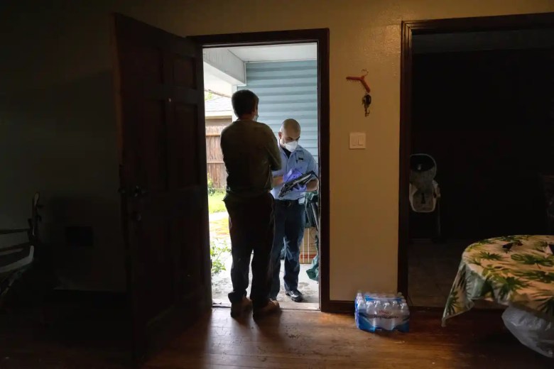 Un paramédico habla con un hombre después de que su esposa muriera en la casa de Covid-19 el 13 de septiembre de 2021 en Houston, Texas. Ella no había sido vacunada, citando temores de la vacuna, pero había planeado para la próxima semana, según su hija.