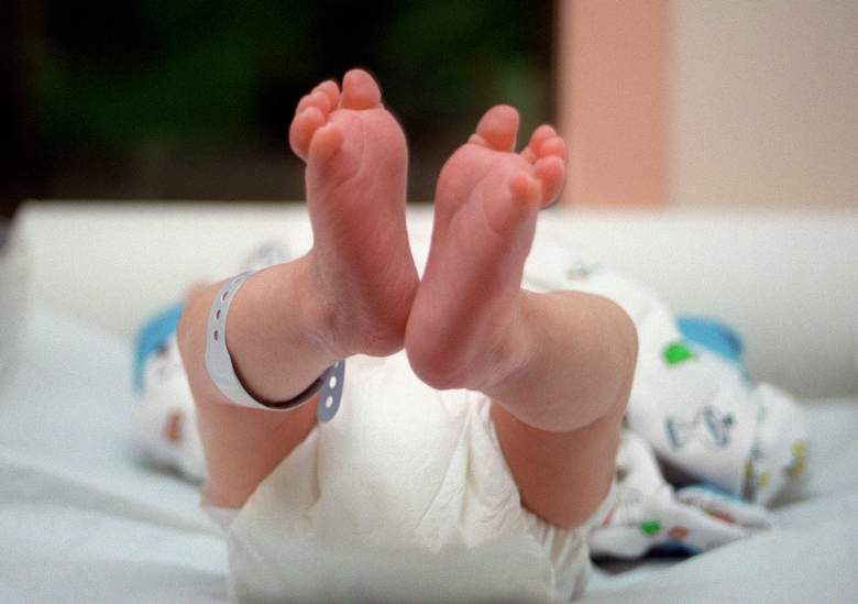 un bebé recién nacido está tendido en un cambiador, el 5 de junio de 2001
