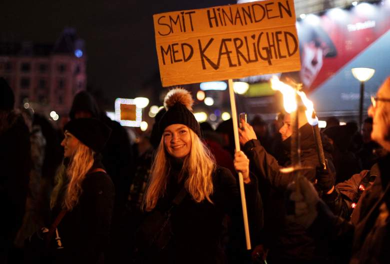 Un manifestante sostiene una pancarta con la leyenda "Infectarse unos a otros con amor" durante una manifestación para protestar contra las restricciones de Covid-19 en Dinamarca en la Plaza del Ayuntamiento (Radhuspladsen) en Copenhague el 9 de enero de 2022,