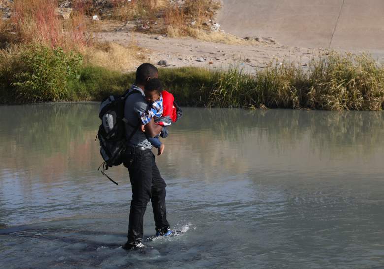 Un migrante haitiano cargando a un bebé cruza el Río Bravo para buscar asilo político en los EE. UU