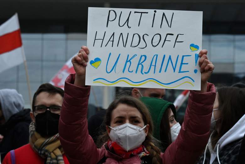 Una mujer sostiene un cartel que dice "Putin Manos Fuera de Ucrania" mientras la gente protesta contra la invasión rusa de Ucrania el 24 de febrero de 2022 en Berlín.