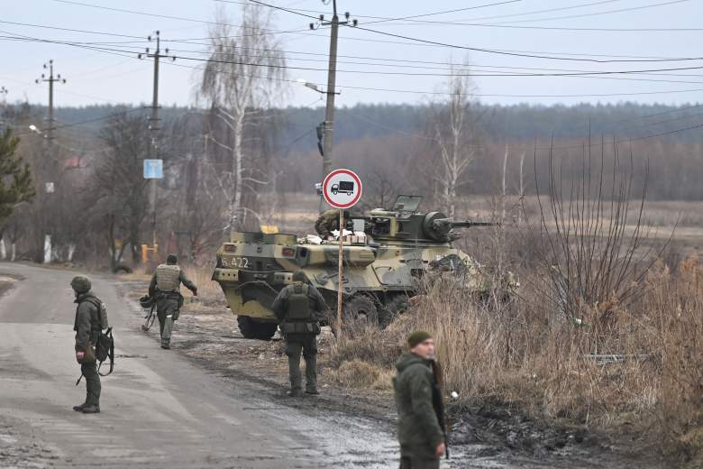 Los militares ucranianos se paran cerca de un vehículo blindado de transporte de personal BTR-3 en el noroeste de Kiev el 24 de febrero de 2022.