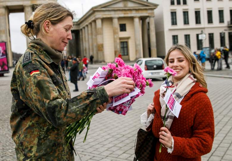 Un soldado de la Bundeswehr entrega un clavel a un transeúnte frente a la histórica Puerta de Brandenburgo en el Día Internacional de la Mujer el 8 de marzo de 2019 en Berlín, Alemania.