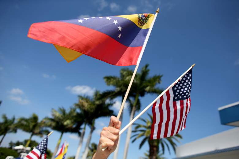 Una manifestante sostiene una bandera venezolana y estadounidense mientras ella y otros venezolanos y sus partidarios muestran su apoyo a las protestas contra el gobierno en Venezuela el 1 de marzo de 2014 en Miami, Florida.