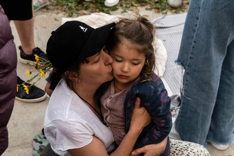 Una mujer besa a un niño en su abrazo durante una manifestación en solidaridad con Ucrania fuera del Centro de Conferencias Filoxenia en el centro de la capital Nicosia, donde la Cámara de Representantes de Chipre se ha reunido durante la pandemia del coronavirus COVID-19, después de un video dirigido a la Parlamento chipriota por el presidente ucraniano, el 7 de abril de 2022.