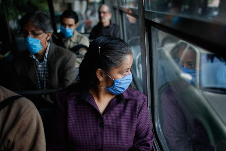 as personas usan máscaras quirúrgicas para ayudar a prevenir la infección con la gripe porcina, mientras viajan en un autobús público el 30 de abril de 2009 en la Ciudad de México, México.