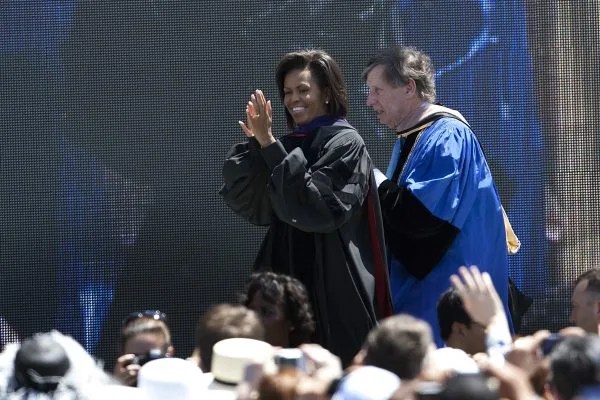 La Primera Dama Michelle Obama entra a la ceremonia de graduación con Richard C. Blum, presidente de Regentes de la Universidad de California, antes de dar el discurso de graduación en la Universidad de California, Merced el 16 de mayo de 2009 en Merced, California.