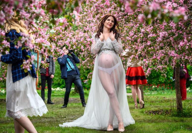 Una mujer embarazada posa para fotografías frente a cerezos en flor en el Parque Kolomenskoye en Moscú el 11 de mayo de 2019.