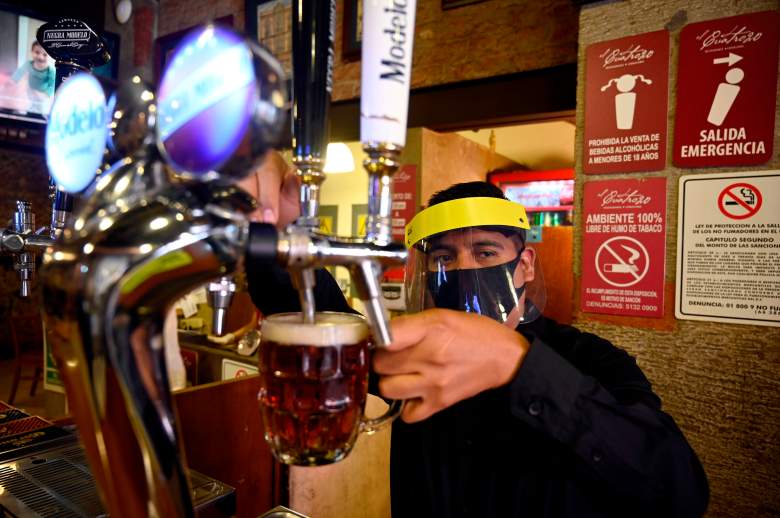 Un trabajador sirve cerveza en un restaurante en la Ciudad de México el 3 de julio de 2020 cuando México autorizó la reapertura de restaurantes, tiendas, mercados callejeros y complejos deportivos, pero con capacidad y horario limitados en medio de la pandemia del nuevo coronavirus COVID-19.