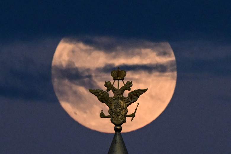 La luna llena, también conocida como Flor de la luna de sangre, se representa detrás del águila bicéfala, el símbolo nacional de Rusia, en lo alto de un edificio en la Plaza Roja en el centro de Moscú el 15 de mayo de 2022.
