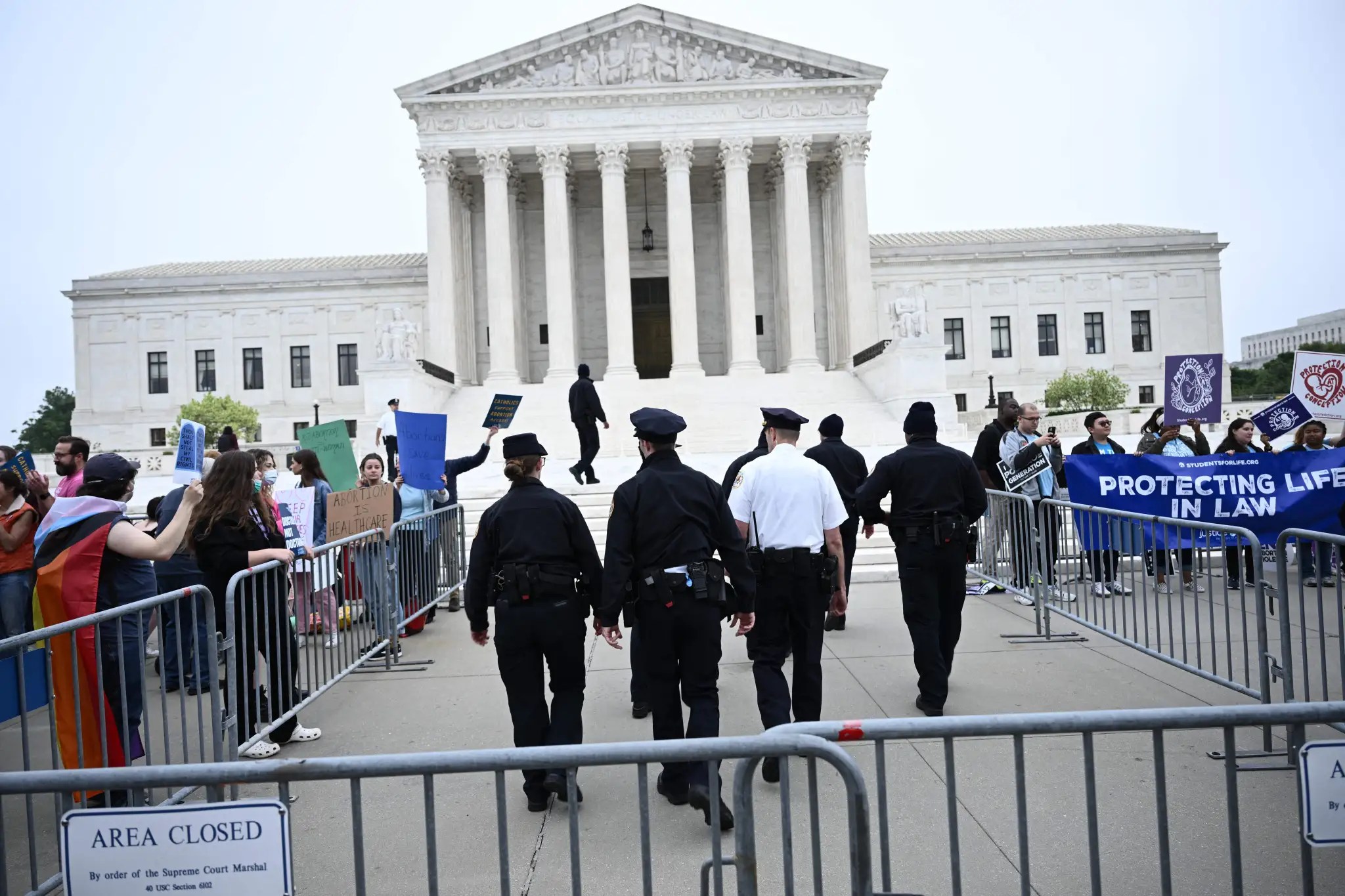 Oficiales de policía caminan hacia la Corte Suprema de EE. UU. mientras los manifestantes se reúnen en Washington, DC, el 3 de mayo de 2022.