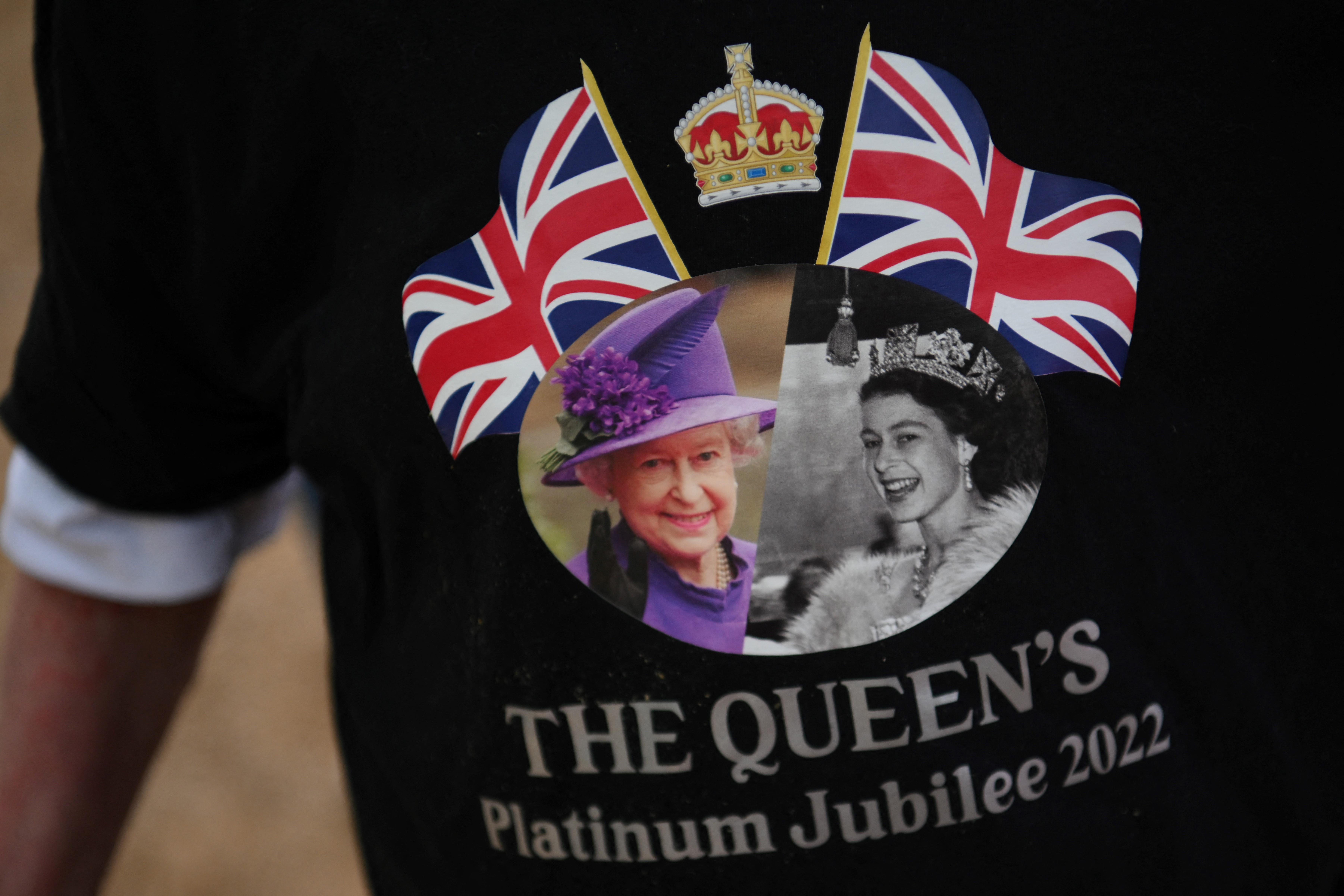 Un visitante con una camiseta que representa a la Reina Isabel II de Gran Bretaña llega a The Mall, en Londres, el 1 de junio de 2022 antes de las celebraciones del Jubileo de Platino para la Reina de Gran Bretaña.