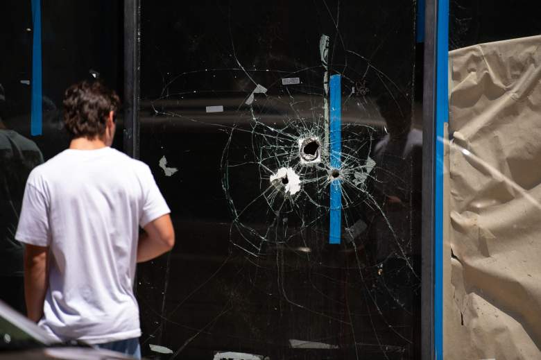 Un peatón pasa junto a agujeros de bala en la ventana de una tienda en South Street en Filadelfia, Pensilvania, el 5 de junio de 2022.