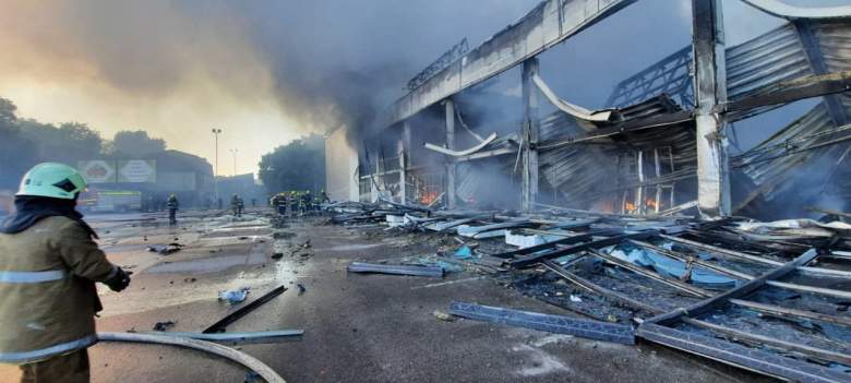 Esta fotografía tomada y publicada por el Servicio Estatal de Emergencias de Ucrania el 27 de junio de 2022 muestra a los bomberos apagando el fuego en un centro comercial afectado por un ataque con misiles rusos en la ciudad de Kremenchuk, en el este de Ucrania, que mató al menos a dos personas e hirió a decenas más.