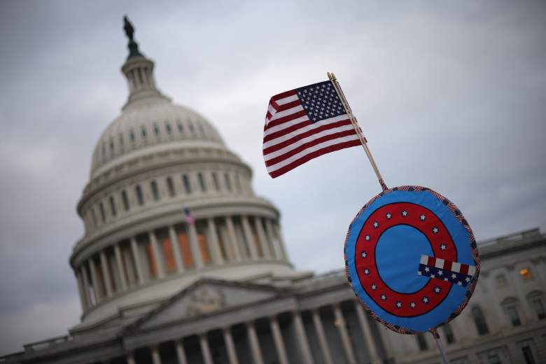 Los partidarios del presidente de los Estados Unidos, Donald Trump, enarbolan una bandera de los Estados Unidos con un símbolo del grupo QAnon mientras se reúnen frente al Capitolio de los Estados Unidos el 6 de enero de 2021 en Washington, DC.
