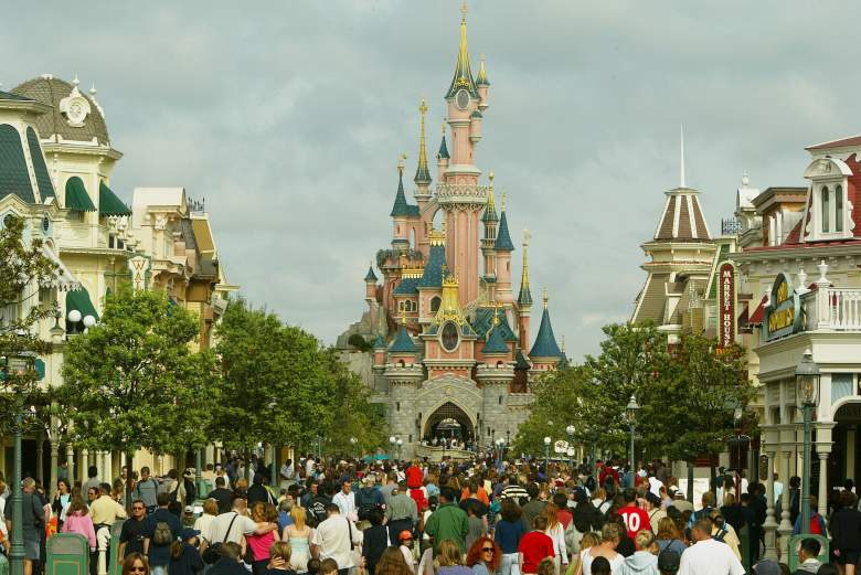 Una multitud de turistas camina hacia el castillo de la Bella Durmiente en la calle principal de Disneyland París el 22 de agosto de 2002 en Marne la Vallee, Francia.
