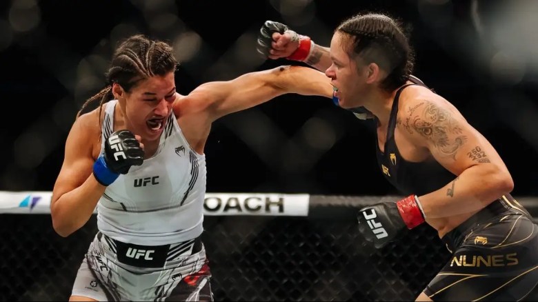 Julianna Pena (L) golpea a Amanda Nunes de Brasil en su pelea por el título de peso gallo femenino durante el evento UFC 269.