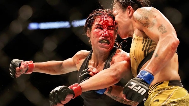 Amanda Nunes de Brasil intercambia golpes con Julianna Pena en su pelea por el título de peso gallo durante UFC 277.