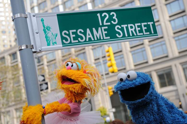 Los personajes de marionetas de Sesame Street Zoe (L) y Cookie Monster (R) posan junto al cartel de la calle temporal el 9 de noviembre de 2009 en West 64th Street y Broadway en Nueva York en vísperas del 40 aniversario de la transmisión del programa de televisión para niños.